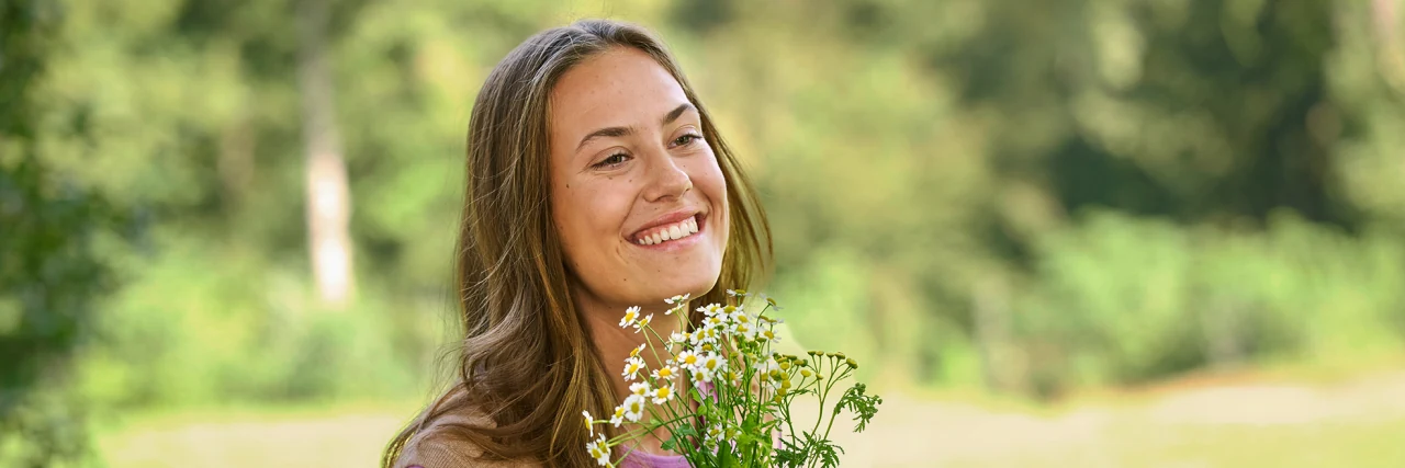 Femme souriante avec des fleurs dans la nature